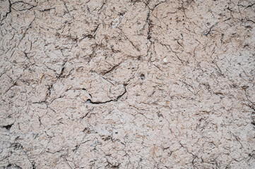 Old cracked wall made of orange clay and straw.