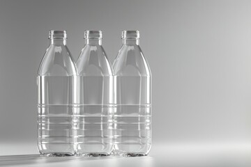 Three transparent plastic bottles of water placed on a flat surface