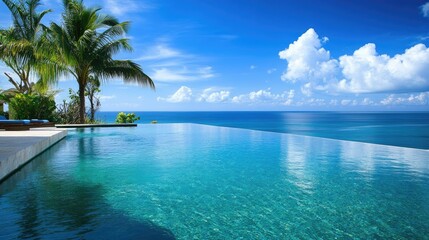 Naklejka premium Scenic view of an infinity pool at a luxury beach resort, where the water appears to flow directly into the ocean beyond.