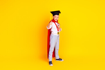 Photo of cheerful happy clever boy graduate wear red cape win competition isolated on yellow color background
