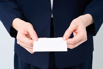 名刺を渡すスーツ姿の女性の手元