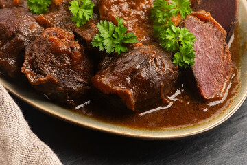 Stewed goose stomach.  Traditional Polish meat on a dark background.