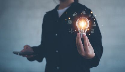  Hand of woman holding illuminated light bulb, Concept for success. Idea innovation and inspiration concept.creativity with bulbs that shine glitter.