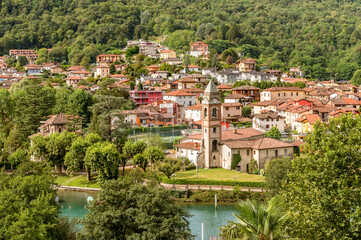 Obraz premium View of the ancient church of Saints Peter and Paul in Lavena Ponte Tresa, overlooks Lake Lugano, province of Varese, Lombardy, Italy