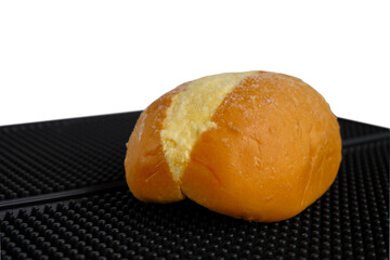 Buns with butter on top, over black mat background.