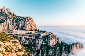 Montserrat mountain range and monastery landscape bathed in a sea of pastel clouds