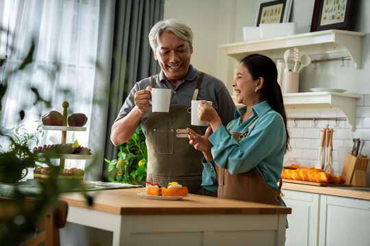 A man and woman are sitting at a table in a kitchen, drinking coffee