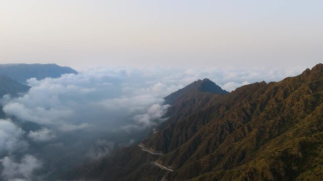 Stunning 4K drone footage of the Sarawat Mountains in Baha, Saudi Arabia. Capture the dramatic contrast of verdant peaks against a backdrop of swirling clouds. Ideal for travel, nature, and cinematic 