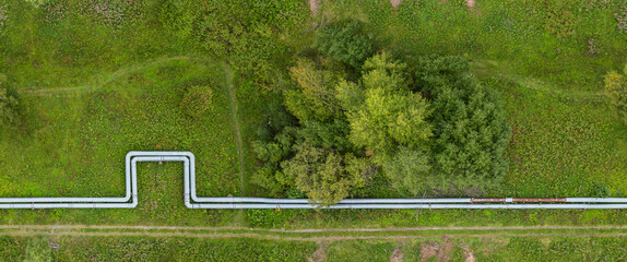 Aerial View of Pipeline Cutting Through Green Field and Trees