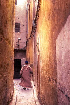 Fez, Morocco - March 19, 2024: Old man with traditional clothes in the narrow streets of the old souk of the medina in Fez, Morocco.