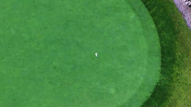 Video of a close view of a golf hole that quickly zooms back and up. Great for adding text, logos, vfx.