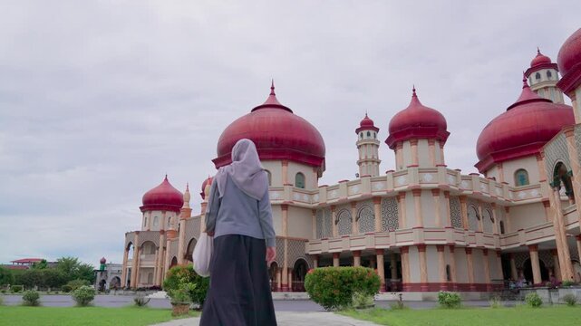 Woman is walking towards the Great Mosque of Baitul Makmur in Indonesia