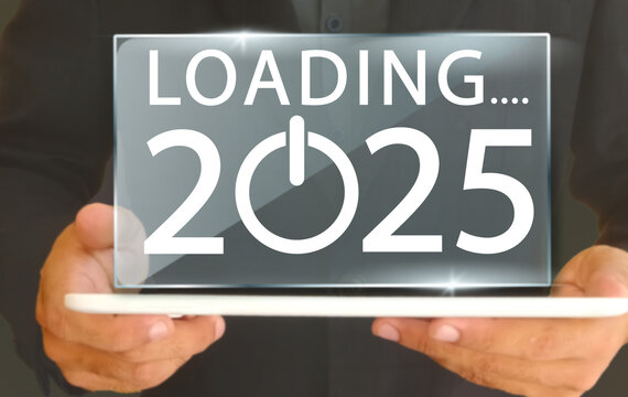 loading 2025 text on screen and tablet in hands in baground in corresponding with starting of 2025.