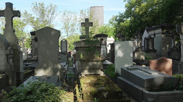 Ancient Parisian cemetery Montparnasse. Tombstones and crypts on graves. Old burial in the shade of trees. Memory of ancestors, peace of mind