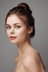 Naklejka premium Portrait of young woman with natural makeup on grey background, studio shot