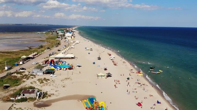 Aerial drone view from above view of the Black Sea coast, hotel on high cliff, light sea waves in summer day, sandy beach, Odessa region, Zatoka, Gribovka, Gribivka, Ukraine.
