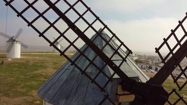 Plano aereo con dron de los molinos de viento de Campo de Criptana con vista general a trav&eacute;s de las aspas de un molino