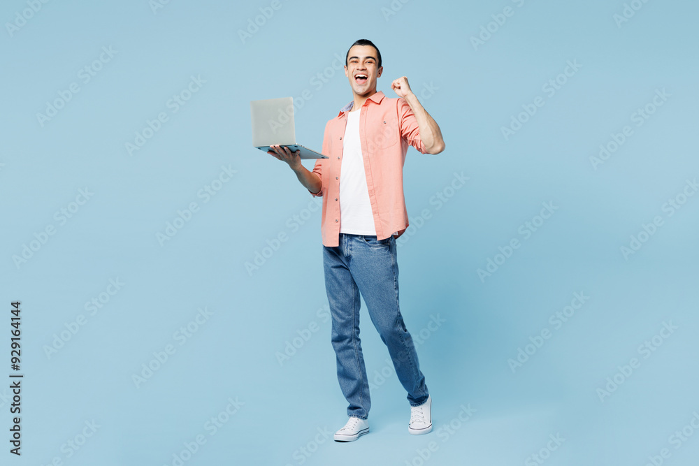 Wall mural full body young it middle eastern man wear pink shirt white t-shirt hold use work on laptop pc compu