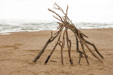 A tipi of driftwood remains on the beach, remnants of a day of fun at the beach in early September at Harrington Beach State Park, Belgium, Wisconsin © Drake Fleege