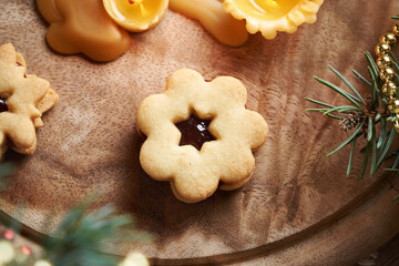 Fototapeta premium Flower shaped Linzer Christmas cookie filled with marmalade with beeswax candle