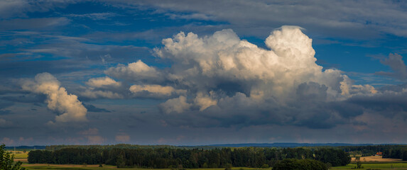 Aufnahme von Regenwolken über einem Waldgebiet.