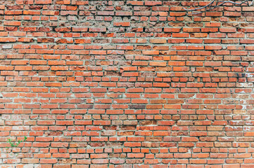 Naklejka premium A brick wall with a few holes in it. The wall is red and has a rough texture