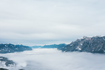 Fototapeta premium Snow-covered mountains above a sea of clouds
