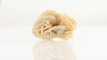 Desert roses mineral stone spinning in a circle on a white background