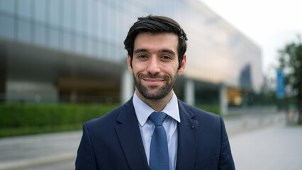 Portrait of smiling business man looking at camera while standing at building. Closeup of successful man smiling at camera while wearing business suit. Happy manager look at camera. Exultant.