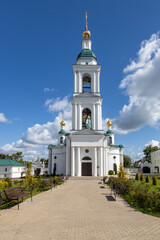 A bright and sunny day at the historic Epiphany Monastery in Uglich, featuring its elegant white bell tower and golden domes against a blue sky