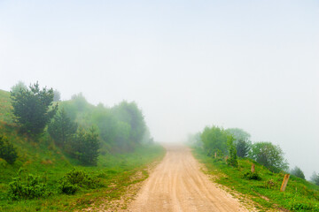 A mountain road high in the mountains among low clouds. The North Caucasus. Russia