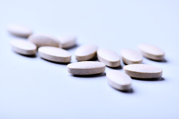 Ashwagandha (Withania somnifera) tablets. Concept for a healthy dietary supplementation. Bright paper background. Close up. Copy space.