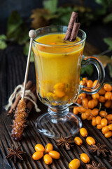 Glass cup of sea buckthorn tea on  dark background