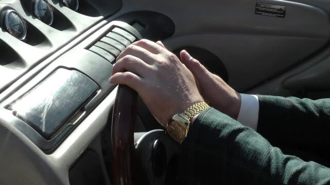 Yacht navigator's hands turn the steering wheel. The helmsman guides the boat through the water.