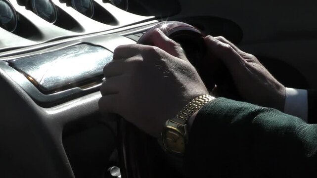 Yacht navigator's hands turn the steering wheel. The helmsman guides the boat through the water.