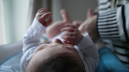 Mother gently dresses her newborn baby on a changing table, ensuring the baby’s comfort and warmth in a nurturing home environment filled with love