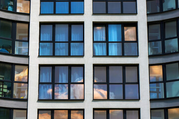 Windows with Black Casements on Facade of Modern Building. Sky Reflections in Windows Glass.     