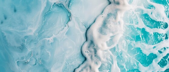 Obraz premium An aerial perspective of a blue and white ocean with foam-topped waves and frothy foam at its base