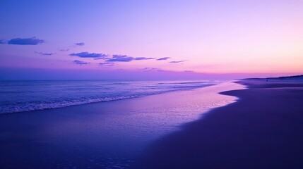 Fototapeta premium A serene beach at sunset with soft waves and a colorful sky.