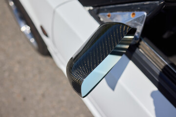 An elegant closeup shot of a sleek car side mirror showcasing its design and details