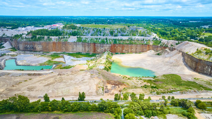 Fototapeta premium Aerial View of Expansive Quarry with Water Bodies and Vegetation