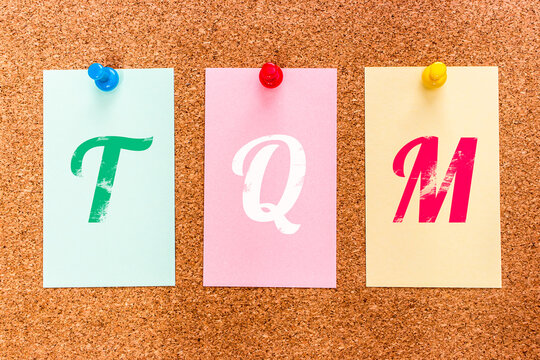 Conceptual 3 letters keyword TQM (Te Quiero Mucho), on multicolored stickers attached to a cork board.