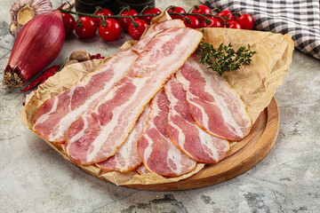 Sliced pork bacon over board