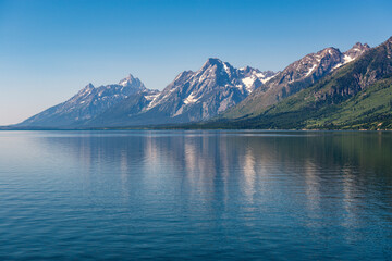 Summer reflection of Grand Teton Mountain Range with snow, Jackson Lake, Grand Teton National Park, Wyoming, United States of America (USA).