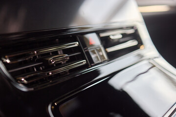 Closeup of car dashboard air vents near gear shift