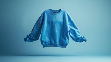 Blue sweatshirt displayed against a soft blue background in a minimalist setting