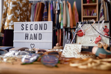 Close up on sign with inscription Second Hand and jewelry case with vintage accessories at thrift...