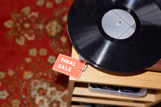 Close up on vintage vinyl record at discounted price with red tag offered for final sale lying on table at second hand shop - Powered by Adobe