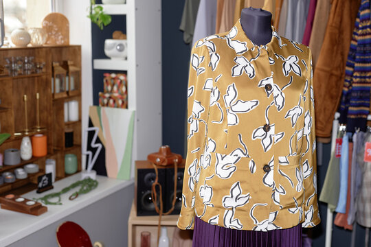 Close up on mannequin displaying vintage light brown shirt standing at second hand shop,