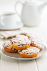 Sweet dessert with sugar coating on plate on white table.